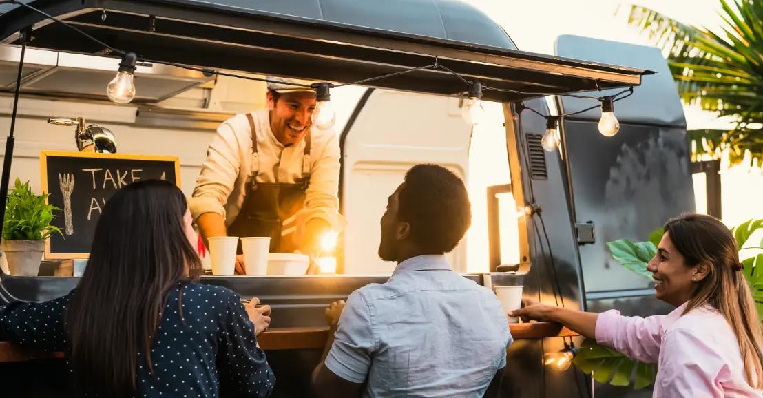 Clients commandant dans un food truck convivial, traiteur via bookmyfoodtruck